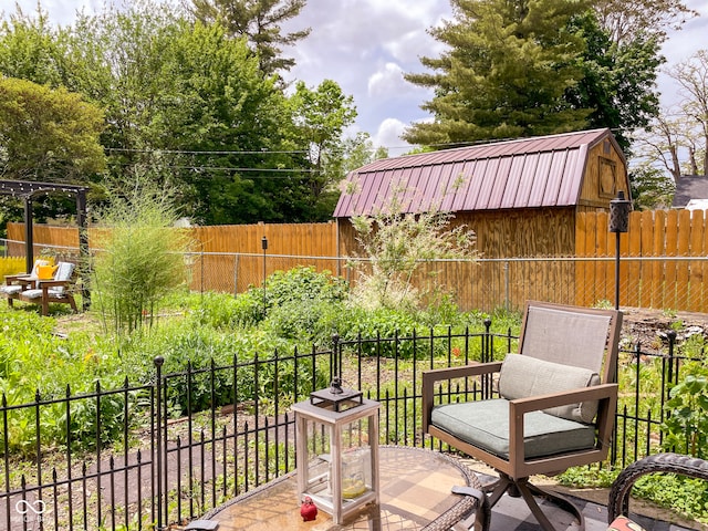 view of patio / terrace featuring a fenced backyard, a shed, and an outbuilding