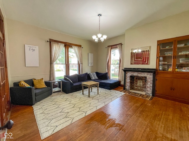 living area with wood finished floors, a chandelier, and a fireplace
