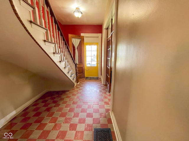 doorway to outside featuring tile patterned floors, baseboards, and stairway