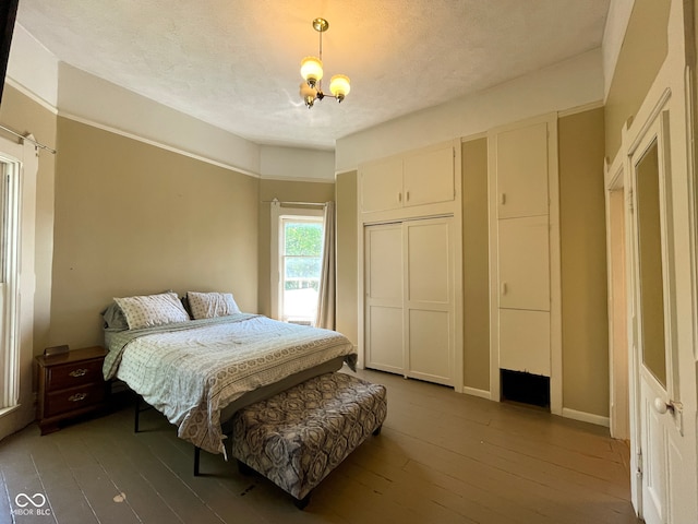 bedroom featuring hardwood / wood-style flooring, a closet, and a chandelier