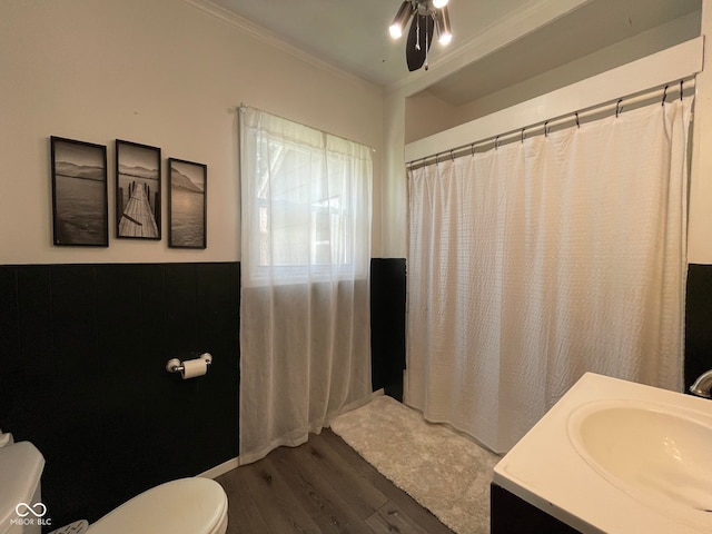 bathroom featuring wood finished floors, toilet, ornamental molding, a ceiling fan, and curtained shower