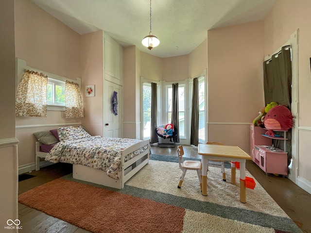 bedroom featuring wood finished floors and baseboards