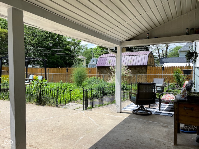 view of patio with a storage unit, an outdoor structure, and a fenced backyard