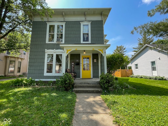 italianate home featuring a front lawn, central AC unit, and covered porch