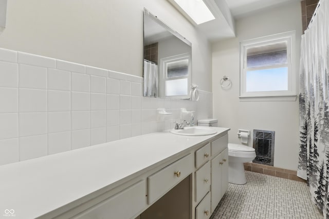 5038 Allisonville Rd Unit E, Indianapolis, IN 46205 - bathroom with toilet, vanity, tile patterned flooring, tile walls, and a wainscoted wall