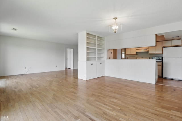 5038 Allisonville Rd Unit E, Indianapolis, IN 46205 - unfurnished living room with light wood-style floors, a chandelier, and built in shelves
