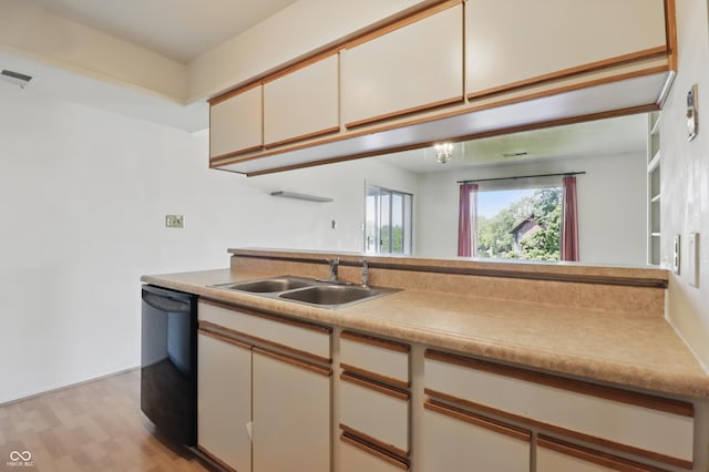 5038 Allisonville Rd Unit E, Indianapolis, IN 46205 - kitchen featuring black dishwasher, a sink, light wood finished floors, light countertops, and cream cabinets
