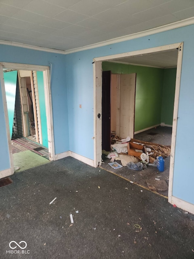 unfurnished room with crown molding, baseboards, and stairway