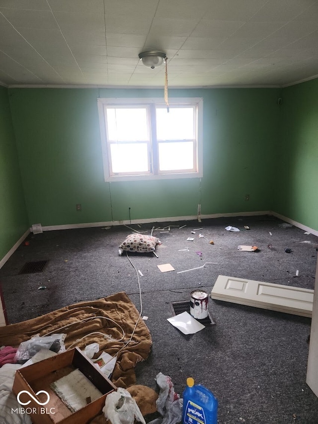 unfurnished room featuring carpet and baseboards