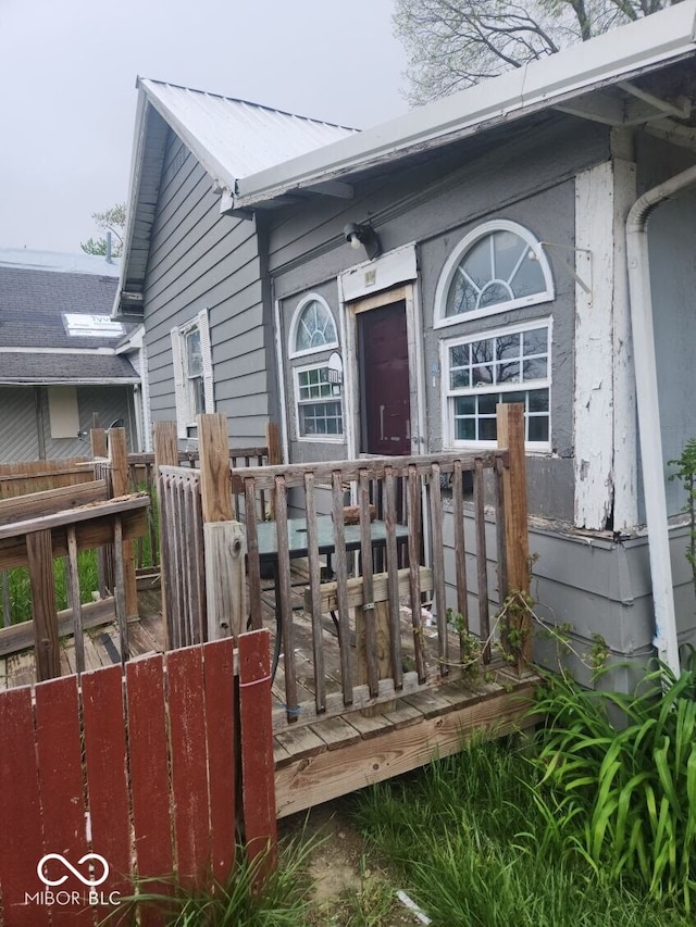 view of exterior entry featuring a wooden deck and metal roof