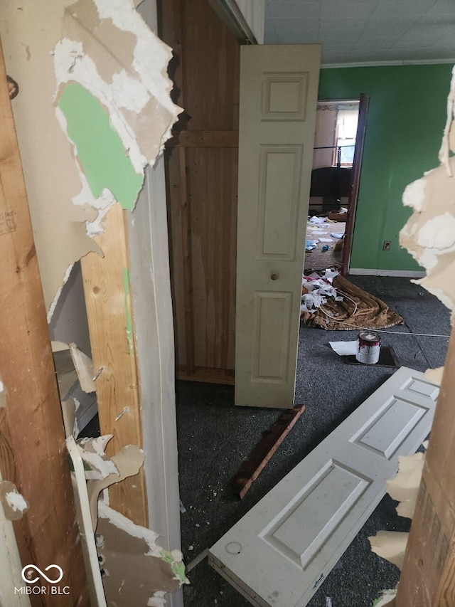 hall featuring crown molding and baseboards