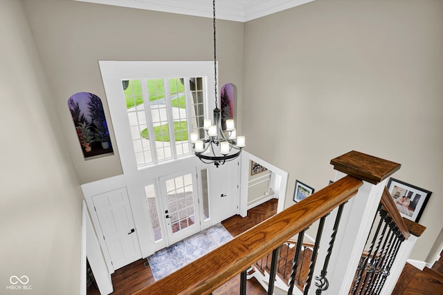 entryway with a chandelier, crown molding, french doors, and stairs