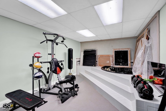 workout area with a paneled ceiling, baseboards, and carpet