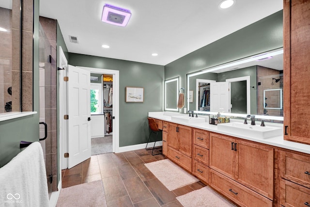 full bathroom featuring a stall shower, double vanity, a walk in closet, baseboards, and recessed lighting