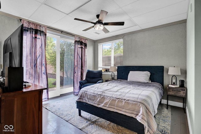 bedroom with a drop ceiling, a ceiling fan, and access to outside