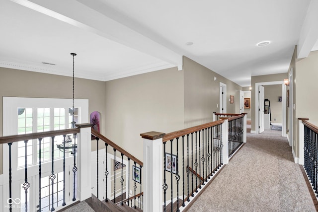 corridor featuring an upstairs landing, carpet floors, baseboards, and crown molding