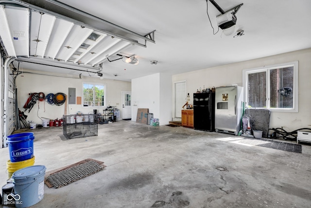 garage featuring freestanding refrigerator, a garage door opener, and electric panel