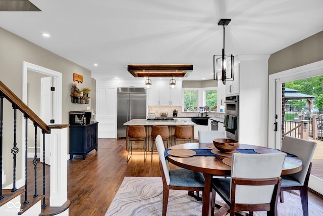 dining area with dark wood finished floors, recessed lighting, and stairs