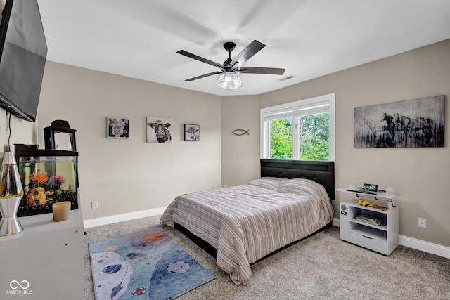 bedroom featuring light colored carpet, baseboards, and a ceiling fan