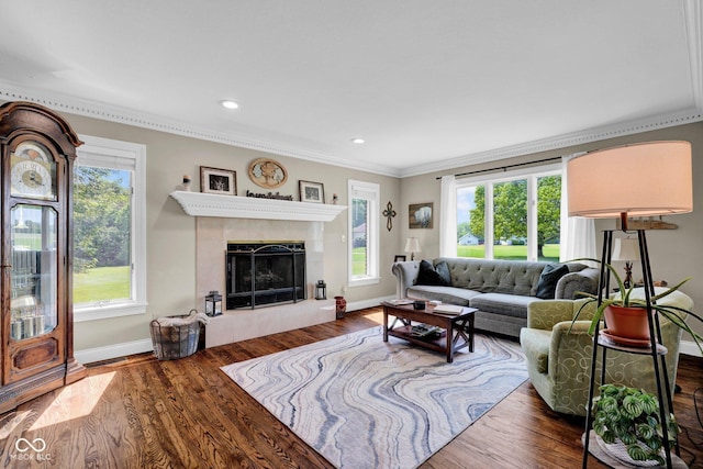 living room with ornamental molding, baseboards, wood finished floors, a tile fireplace, and recessed lighting