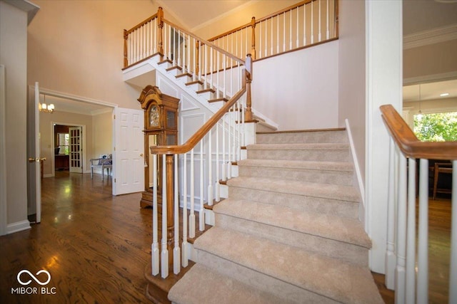 11536 Woods Bay Ln, Indianapolis, IN 46236 - stairs featuring crown molding, baseboards, a towering ceiling, and wood finished floors