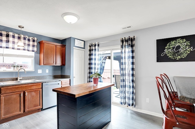 kitchen featuring a sink, stainless steel dishwasher, wooden counters, light wood-style flooring, and plenty of natural light