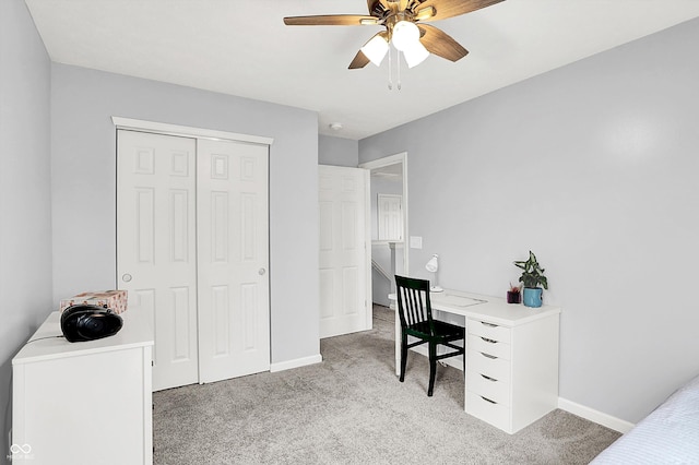 office area with light colored carpet, ceiling fan, and baseboards