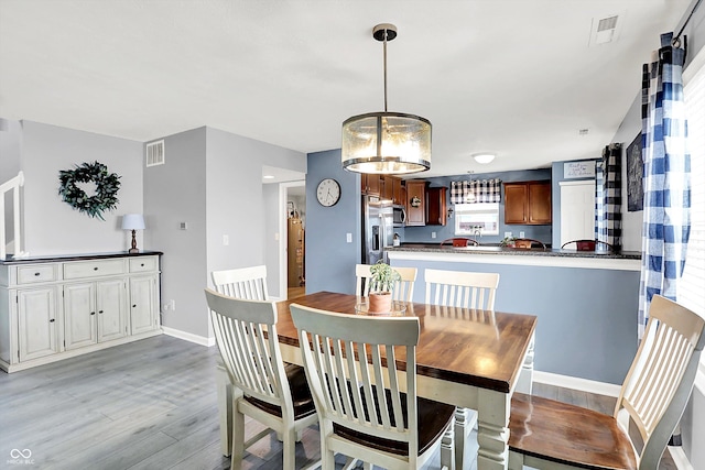 dining room featuring light wood-style floors and baseboards