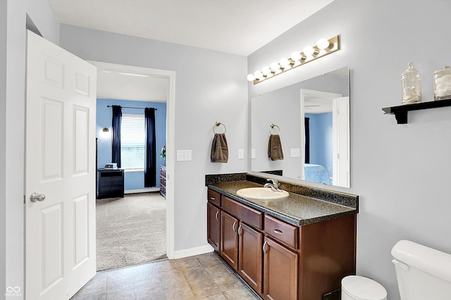 bathroom featuring ensuite bathroom, vanity, toilet, and baseboards
