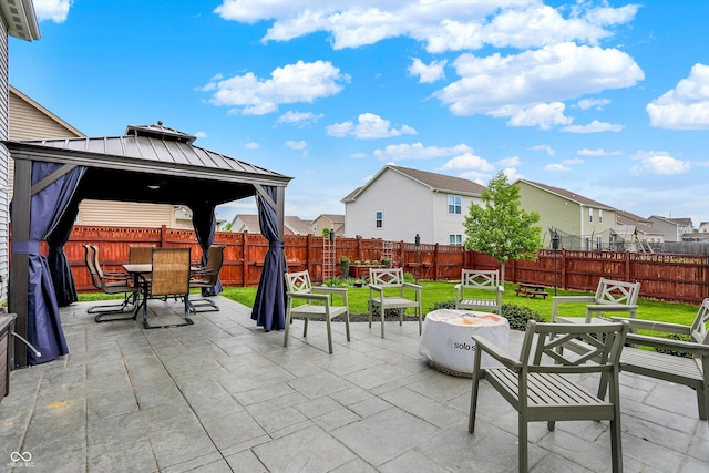 view of patio / terrace featuring a gazebo, an outdoor fire pit, outdoor dining area, and a residential view