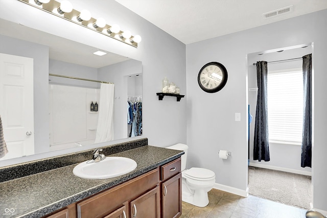 full bath with toilet, baseboards, plenty of natural light, and vanity