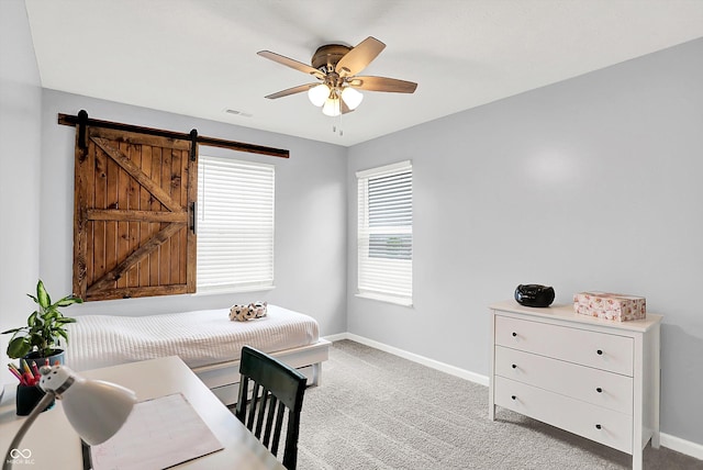 office with ceiling fan, baseboards, light carpet, and a barn door