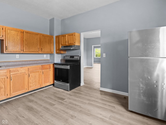 1225 S Monroe St, Muncie, IN 47302 - kitchen featuring stainless steel appliances, under cabinet range hood, light countertops, baseboards, and light wood finished floors