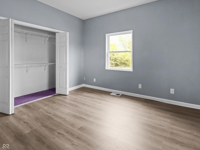 1225 S Monroe St, Muncie, IN 47302 - unfurnished bedroom featuring a closet, wood finished floors, and baseboards