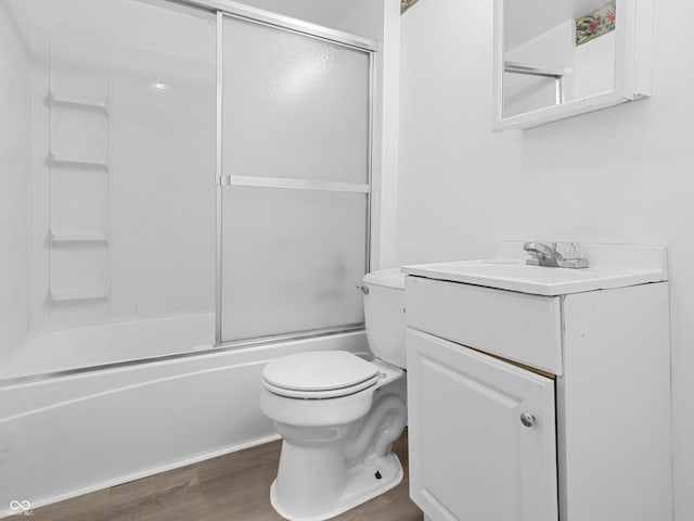 1225 S Monroe St, Muncie, IN 47302 - bathroom featuring wood finished floors, toilet, vanity, and bath / shower combo with glass door
