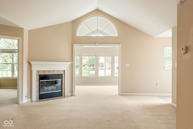 11438 Winding Wood Dr, Indianapolis, IN 46235 - unfurnished living room with carpet, a tile fireplace, vaulted ceiling, and healthy amount of natural light