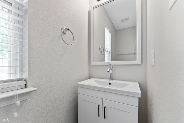 bathroom with vanity and a textured wall