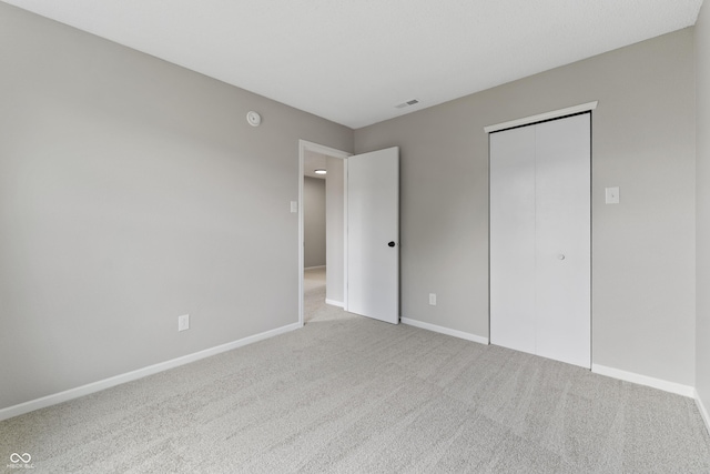 unfurnished bedroom featuring carpet, baseboards, and a closet