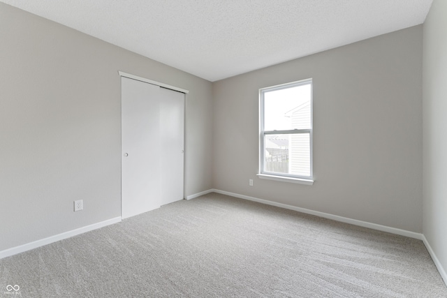 carpeted empty room featuring baseboards