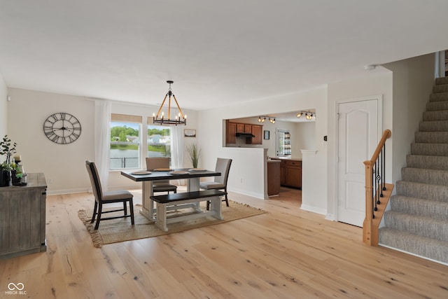 8238 Crackling Ln, Indianapolis, IN 46259 - dining room with stairs, a chandelier, light wood finished floors, and plenty of natural light