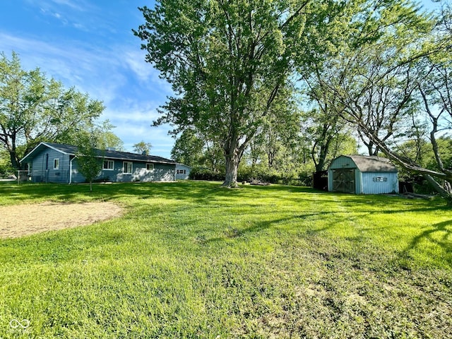 view of green lawn with a storage shed and an outbuilding