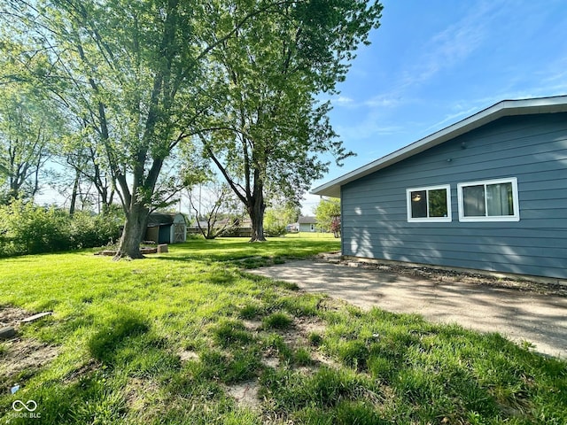 view of grassy yard featuring a storage shed and an outdoor structure