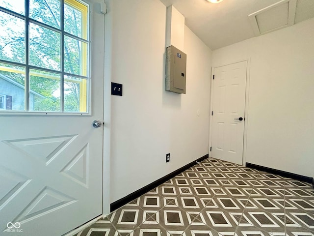 doorway with electric panel, baseboards, and tile patterned floors