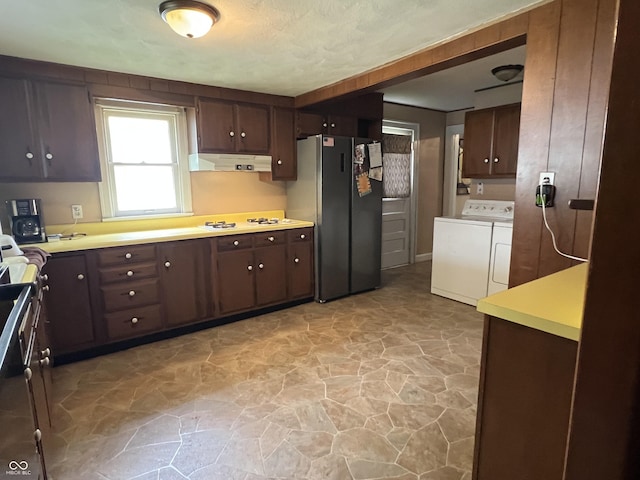 1122 S 21st St, New Castle, IN 47362 - kitchen featuring washing machine and dryer, under cabinet range hood, freestanding refrigerator, stone floors, and white stovetop
