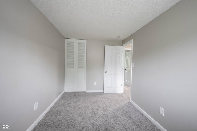 2740 Pawnee Dr, Indianapolis, IN 46229 - unfurnished bedroom with carpet flooring, a textured ceiling, baseboards, and a closet