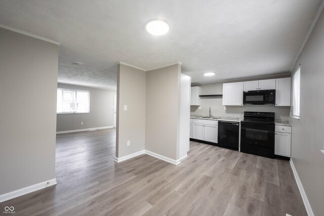 2740 Pawnee Dr, Indianapolis, IN 46229 - kitchen with black appliances, a sink, baseboards, white cabinets, and ornamental molding