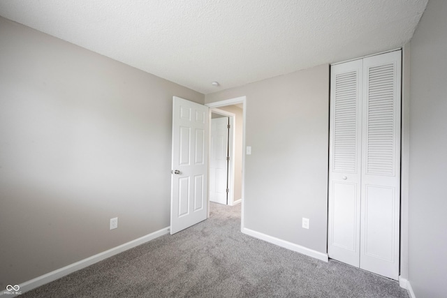 2740 Pawnee Dr, Indianapolis, IN 46229 - unfurnished bedroom featuring carpet flooring, baseboards, a closet, and a textured ceiling
