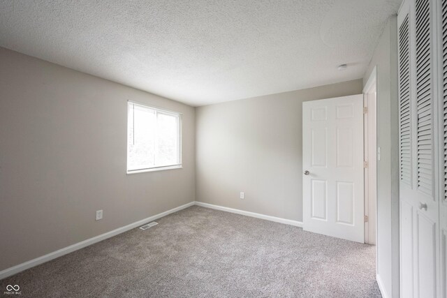 2740 Pawnee Dr, Indianapolis, IN 46229 - unfurnished bedroom with carpet floors, a closet, a textured ceiling, and baseboards
