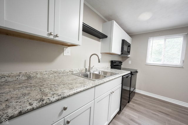 2740 Pawnee Dr, Indianapolis, IN 46229 - kitchen featuring black appliances, a sink, white cabinets, light wood-style flooring, and baseboards