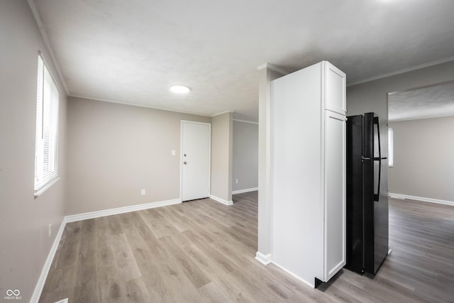 2740 Pawnee Dr, Indianapolis, IN 46229 - kitchen featuring freestanding refrigerator, white cabinetry, light wood-type flooring, and baseboards